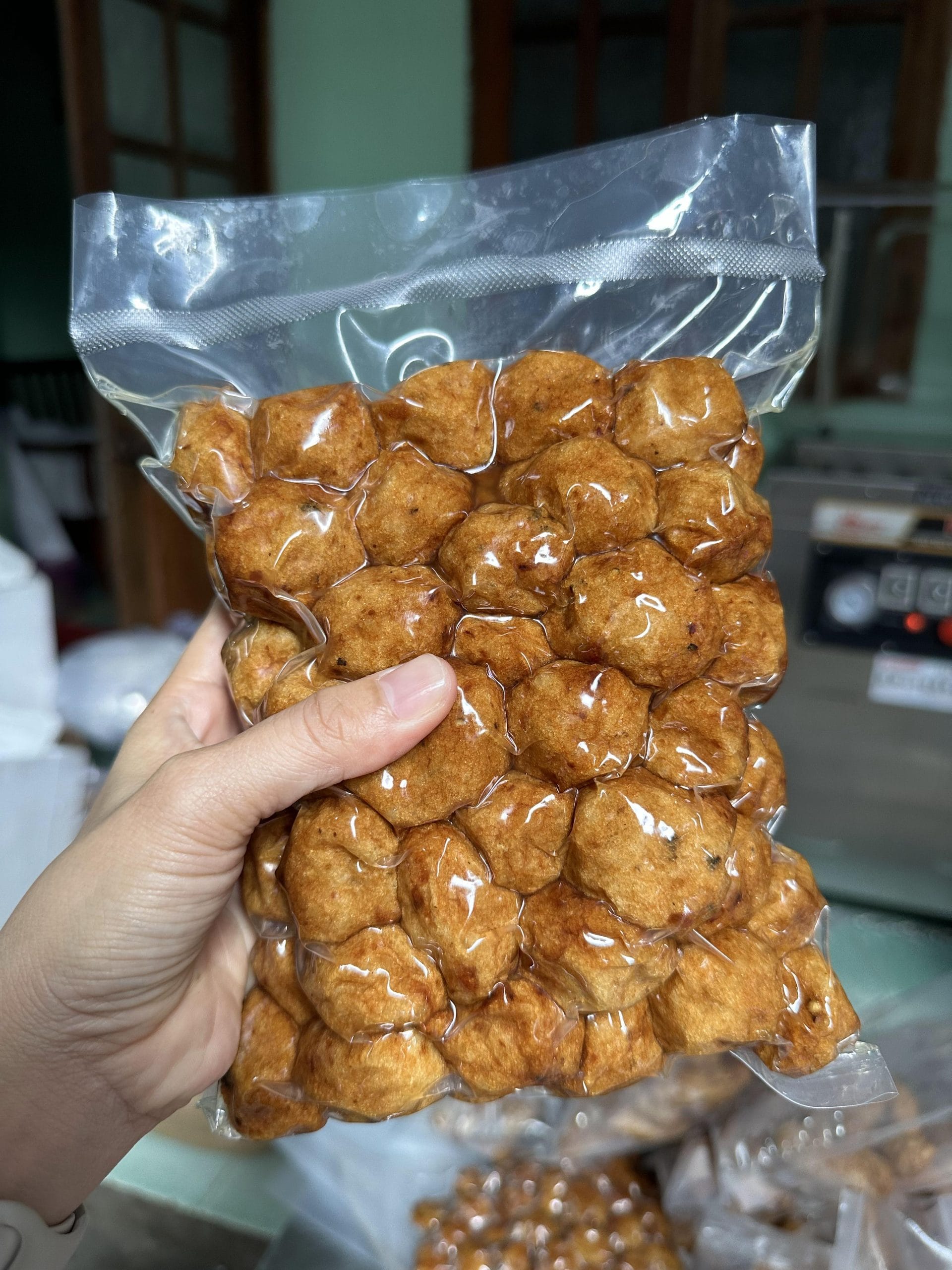 Chả cá viên bi hấp đóng gói hút chân không cầm trên tay