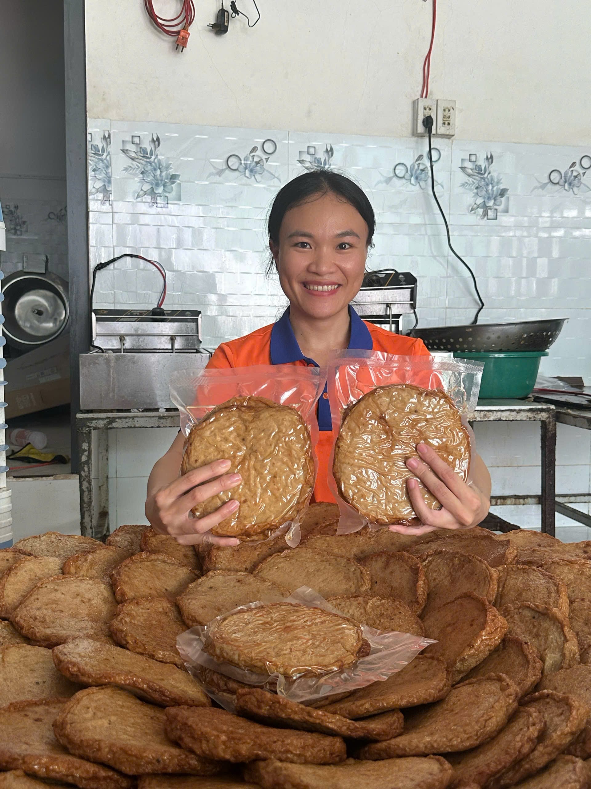 Chả Cá Nha Trang Nấu Món Gì Ngon? Gợi Ý Cách Chế Biến Tại Nhà 1 Nhân viên Xóm Biển cầm 2 gói chả cá chiên trước núi chả cá thành phẩm