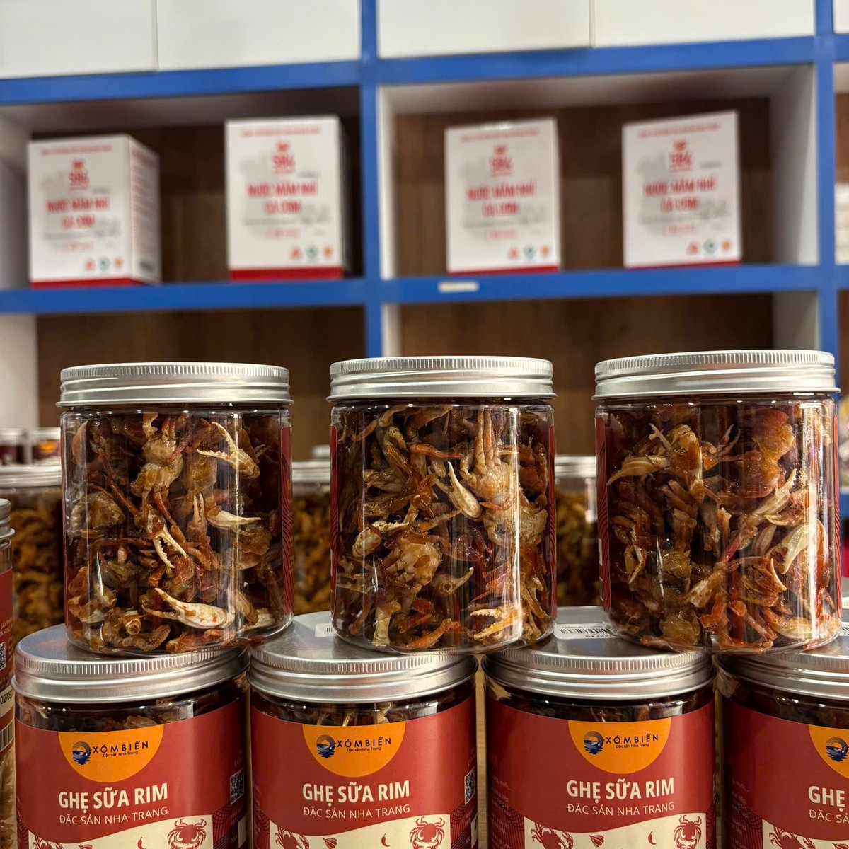 Ghẹ Sữa Rim Là Gì? Ăn Nguyên Con Được Không 3 Hũ ghẹ sữa rim xếp tại cửa hàng Xóm Biển